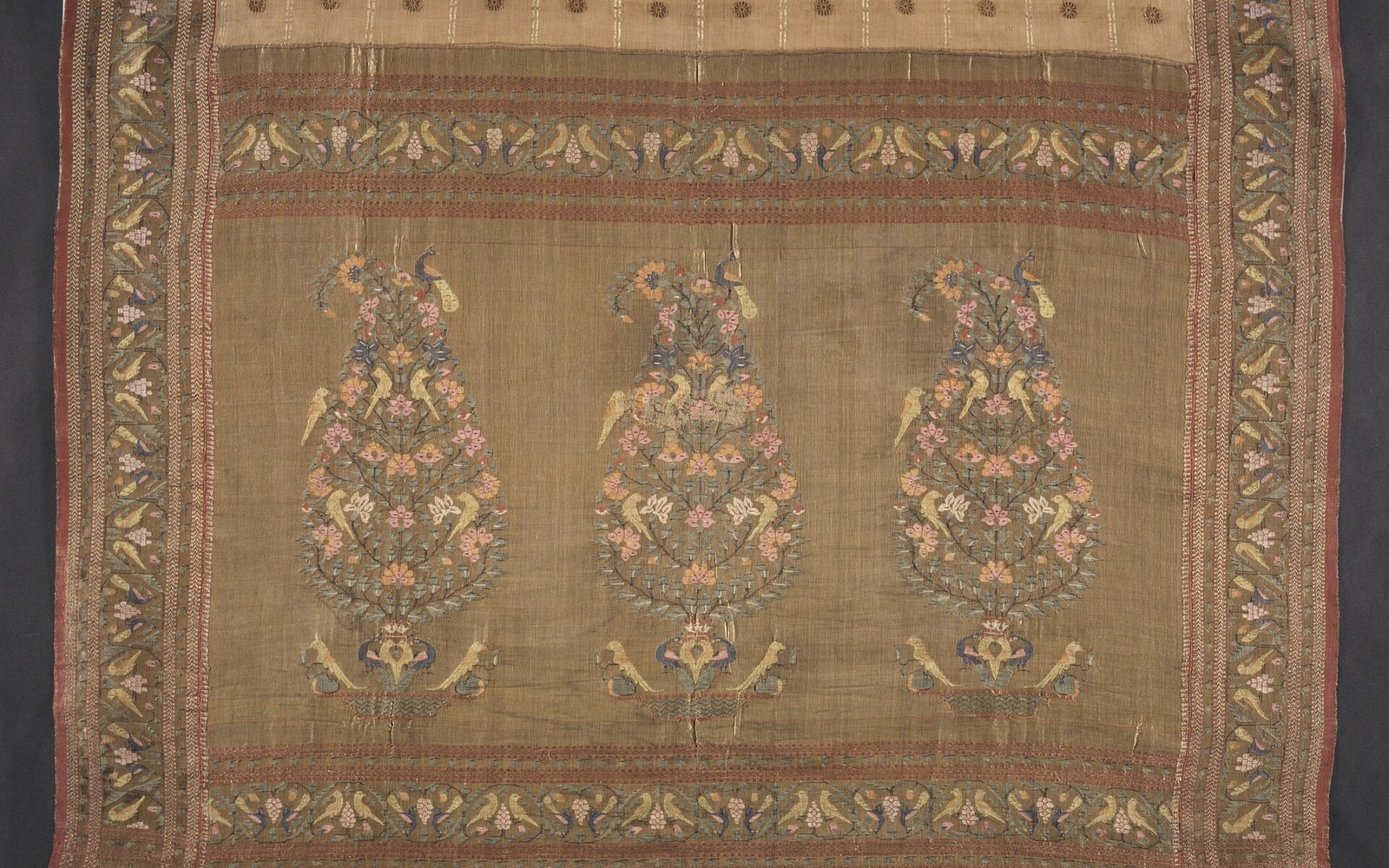 Three repeating floral bouquet motifs woven into a brocaded sari with paisley and vine borders